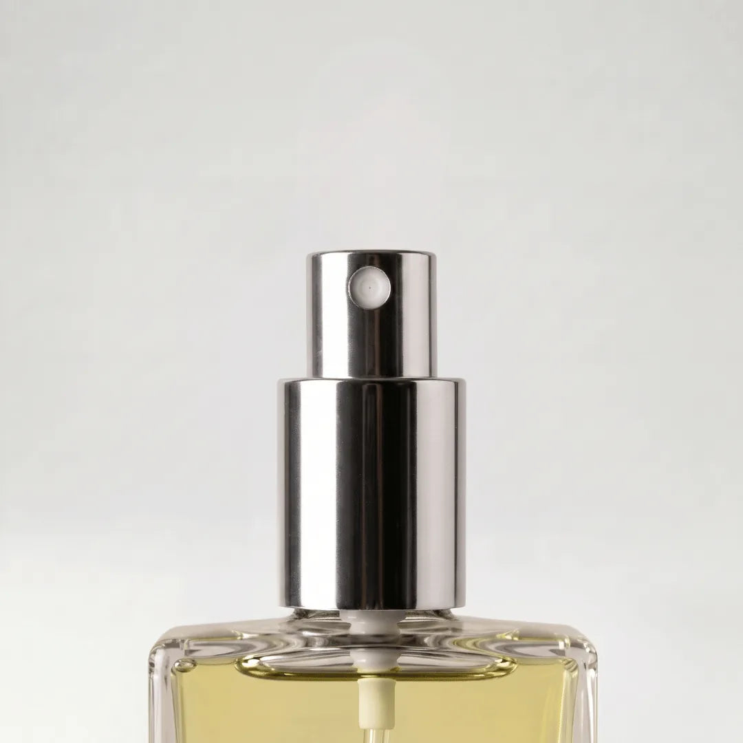 Acercamiento al atomizador plateado del frasco de Brezza